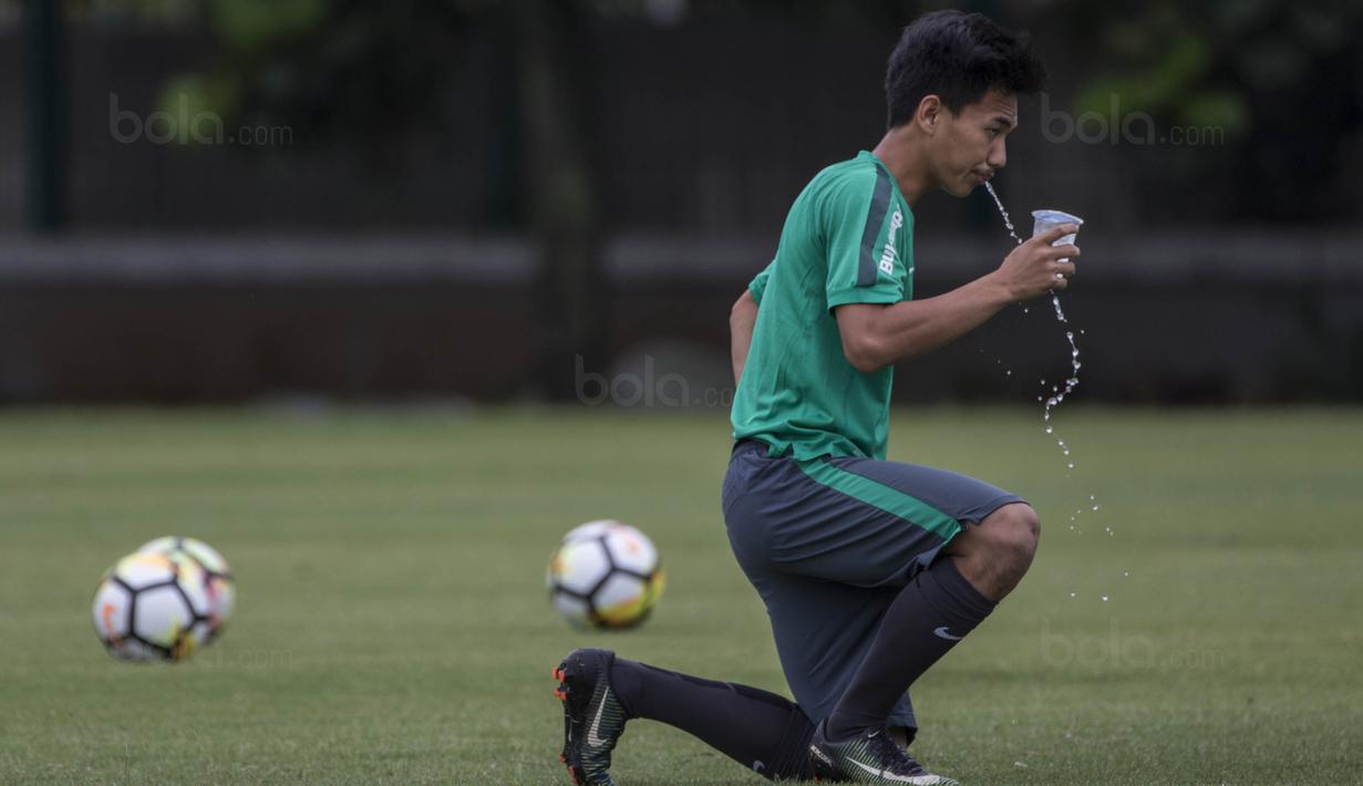 Gelandang Timnas Indonesia, Muhammad Iqbal, melepas dahaga saat latihan di Lapangan ABC Senayan, Jakarta, Jumat (19/1/2018). Pemusatan latihan ini dilakukan jelang Asian Games 2018. (Bola.com/Vitalis Yogi Trisna)