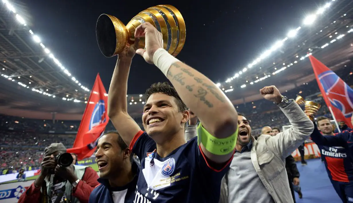 Sang kapten PSG, Thiago Silva memegang tropi dan merayakan kemenangan timnya di Stade de France, Sabtu (19/4/2014) (AFP Photo/Franck Fife).