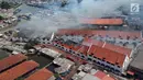 Foto udara menunjukkan petugas pemadam kebakaran memadamkan sisa api yang membakar Museum Bahari, Jakarta Utara, Selasa (16/1). Untuk menjinakan api, petugas pemadam kebakaran mengerahkan 21 unit mobil pemadam. (Liputan6.com/Arya Manggala)