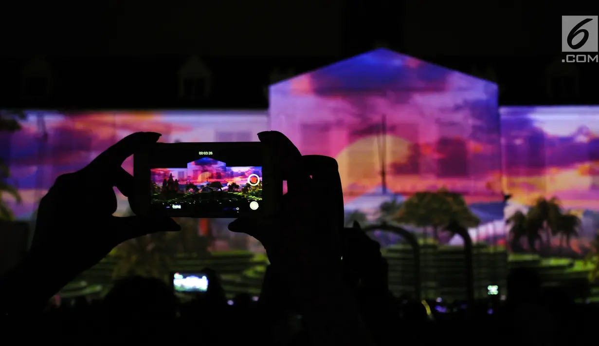 Warga mengabadikan pertunjukan projection mapping di depan area Museum Fatahillah, Jakarta, Jumat (19/1). Pertunjukan ini menandai rangkaian kegiatan perayaan 60 tahun hubungan diplomatik Indonesia-Jepang. (Liputan6.com/Helmi Fithriansyah)