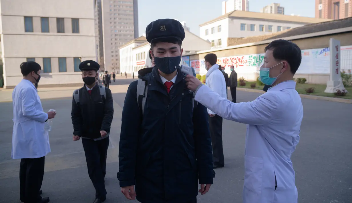 Mahasiswa menjalani pemeriksaan suhu sebagai upaya mencegah penyebaran pandemi Covid-19 di Universitas Kedokteran Pyongyang di Pyongyang, Rabu (22/4/2020). Korea Utara memberlakukan pembatasan ketat guna mengantisipasi penyebaran pandemi yang telah menyebar hampir di seluruh dunia. (KIM Won Jin/AFP)