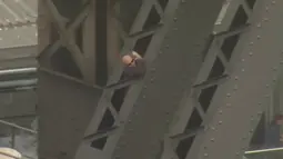 Seorang pria berbaju hitam dan berkaca mata sedang menaiki jembatan Sydney Harbour, Australia, (17/6). Belum diketahui motif apa yang membuat pria tersebut menaiki jembatan yang menjadi landmark Australia tersebut. (SEVEN NETWORK/via REUTERS TV)