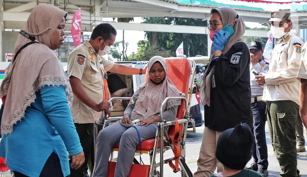 Petugas Dinas Kesehatan DKI Jakarta melakukan evakuasi kepada seorang warga yang mengalami pendarahan karena kelelahan saat CFD di Kawasan Bundaran HI, Jakarta, Minggu (14/8/2022). Warga tersebut langsung mendapatkan penanganan medis dan di bawa ke rumah sakit terdekat. (Liputan6.com/Angga Yuniar)