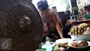 Buang Jayadi (74), melakukan ritual khusus sebelum memainkan gong sakral tersebut di Depok, 14 Januari 2017. Suaranya yang keras dan terdengar dari kejauhan menjadi ciri khas Gong Si Bolong, seperti permainan gong khas Bali. (Liputan6.com/Helmi Afandi)