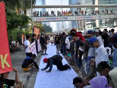 Sejumlah warga membubuhkan tanda tangan mendukung pemakzulan Gubernur DKI Basuki Tjahaja Purnama alias Ahok di Bundaran HI, Jakarta, Minggu (22/2/2015). Mereka melakukan aksi ini karena kebijakan Ahok dinilai tak pro-rakyat. (Liputan6.com/Faizal Fanani)
