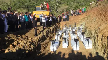 Pemakaman massal korban banjir bandang di Sentani, Kabupaten Jayapura, Papua, Rabu (27/3). Sebanyak 20 jenazah korban banjir bandang Sentani dimakamkan secara massal lantaran belum berhasil teridentifikasi.  (NETHY DHARMA SOMBA/AFP)