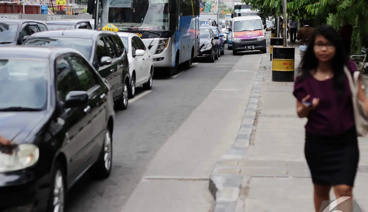 Seorang pejalan kaki berjalan di trotoar sekitar jalan MH Thamrin, Jakarta, Rabu (17/12/2014). (Liputan6.com/Faizal Fanani) 