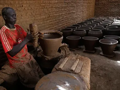 Pekerja membuat pot tanah liat di sebuah bengkel tembikar di Khartoum, Sudan, Kamis (27/6/2019). Pot tanah liat tersebut nantinya akan dipajang untuk dijual. (AP Photo/Hussein Malla)