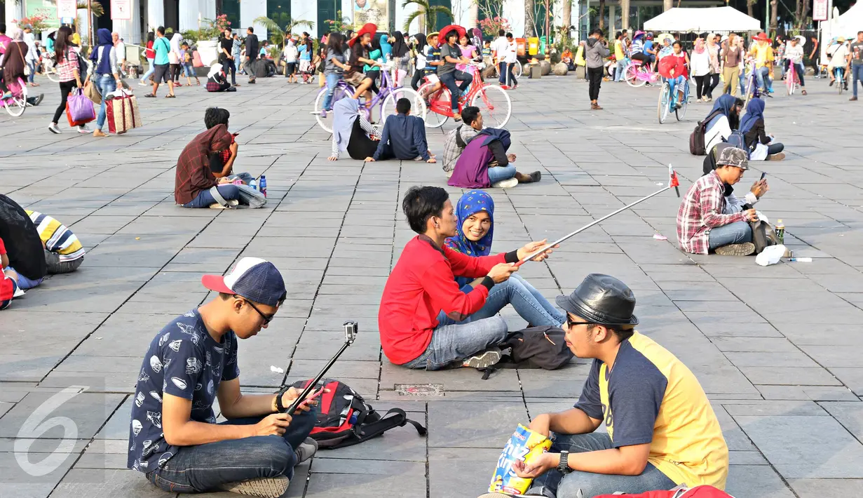 Sejumlah remaja berfoto bersama saat berwisata di Kota Tua, Jakarta, Minggu (8/5). Keunikan bangunan tua di kawasan tersebut menjadi daya tarik tersendiri bagi warga untuk melakukan foto bersama atau selfie. (Liputan6.com/Immanuel Antonius)