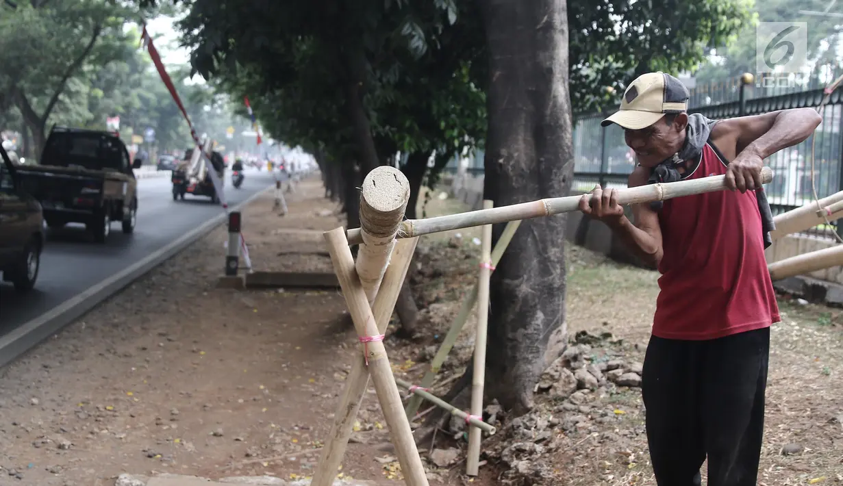 Penjual mengerjakan pohon pinang untuk lomba memanjat dalam rangka menyemarakkan HUT Kemerdekaan RI yang dijual di kawasan Tanjung Barat, Jakarta, Kamis (8/8). Batang pinang itu dijual dengan harga mulai dari Rp 700ribu. (Liputan6.com/Herman Zakharia)