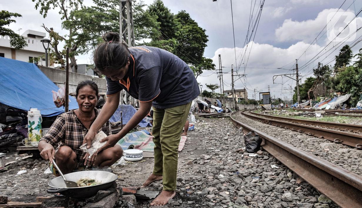 Tunawisma beraktivitas di dekat gubuknya yang berada di bantaran rel kereta api kawasan Senen, Jakarta, Minggu (14/2/2021). Mayoritas penghuni bantaran rel di kawasan ini adalah pemulung dengan rata-rata berpenghasilan Rp30ribu per hari. (merdeka.com/Iqbal S. Nugroho)