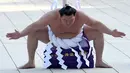 Juara Grand Sumo asal Mongolia, Hakuho melakukan upacara tradisional mengentakkan kaki untuk menyambut tahun baru di Kuil Shinto Meiji Shrine, Tokyo, Selasa (9/1).  Pesumo itu mengentakkan ke tanah dengan sekuat tenaga. (Toshifumi KITAMURA / AFP)
