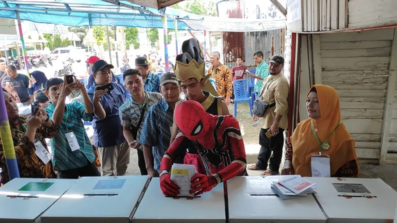 Spiderman memasukkan surat suara yang sudah dicoblosnya ke kotak suara.