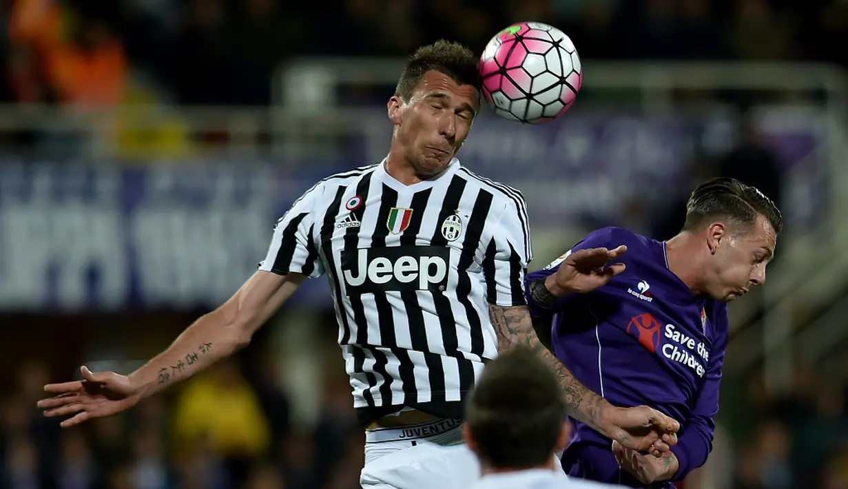 Striker Juventus, Mario Mandzukic (kiri), berduel dengan pemain Fiorentina, Federico Bernardeschi, dalam lanjutan Serie A di Stadion Artemio Franchi, Firenze, Senin (25/4/2016) dini hari WIB. (AFP/Alberto Pizzoli)
