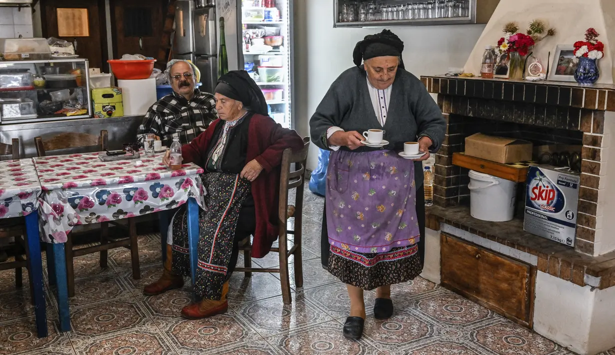Para perempuan Olympos yang lebih tua secara tradisional mengenakan kostum bersulam yang terdiri dari celemek bermotif bunga, kerudung, dan sepatu bot kulit. (Louisa GOULIAMAKI / AFP)