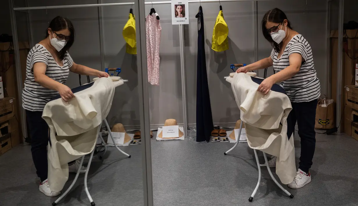 Staf desainer Spanyol, Devota dan Lomba bekerja di belakang panggung sehari sebelum dimulainya Mercedes-Benz Fashion Week di Madrid, Rabu (9/9/2020). Mode Spanyol berlangsung dari 10 - 13 September di bawah protokol kesehatan dan pedoman jarak sosial karena pandemi corona. (AP Photo/Bernat Armangue)