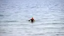 Seorang pria berenang di laut Baltik di Gdynia, Polandia utara (24/5/2019). Dalam bahasa Jerman, laut ini disebut Ostsee yang sebenarnya berarti "laut Timur". (AP Photo/Darko Vojinovic)