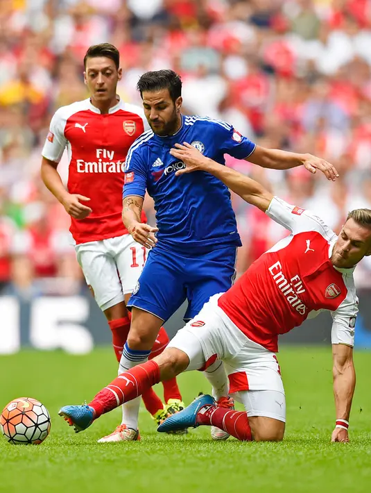 Gelandang Chelsea, Cesc Fabregas (tengah) berusaha melewati gelandan Arsenal, Aaron Ramsey pada pertandingan FA Community Shield di Wembley Stadium, Minggu (2/8/2015). Arsenal menang atas Chelsea dengan skor 1-0. (Reuters/Dylan Martinez)