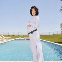 Istri Travis Barker ini tampil dengan jumpsuit ketat warna baby bump serta halter neck nya. Dipadukan sandal putihnya.  @kourtneykardash