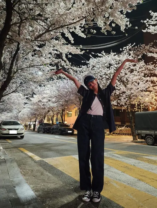 Lia ITZY memilih malam hari sebagai waktu yang pas untuk menonton bunga. Coba bayangkan berjalan di trotoar yang dinaungi "koridor" cherry blossom yang tengah berbunga ini. Romantis, bukan?  (Instagram/ itzy.all.in.us)