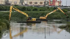Sejumlah alat berat mengeruk endapan lumpur Waduk Pluit yang menyusut debit airnya di Jakarta, Kamis (18/2). Pengerukan itu bertujuan untuk mengangkat sedimen dan sampah yang mengakibatkan pendangkalan waduk. (Liputan6.com/Faizal Fanani)