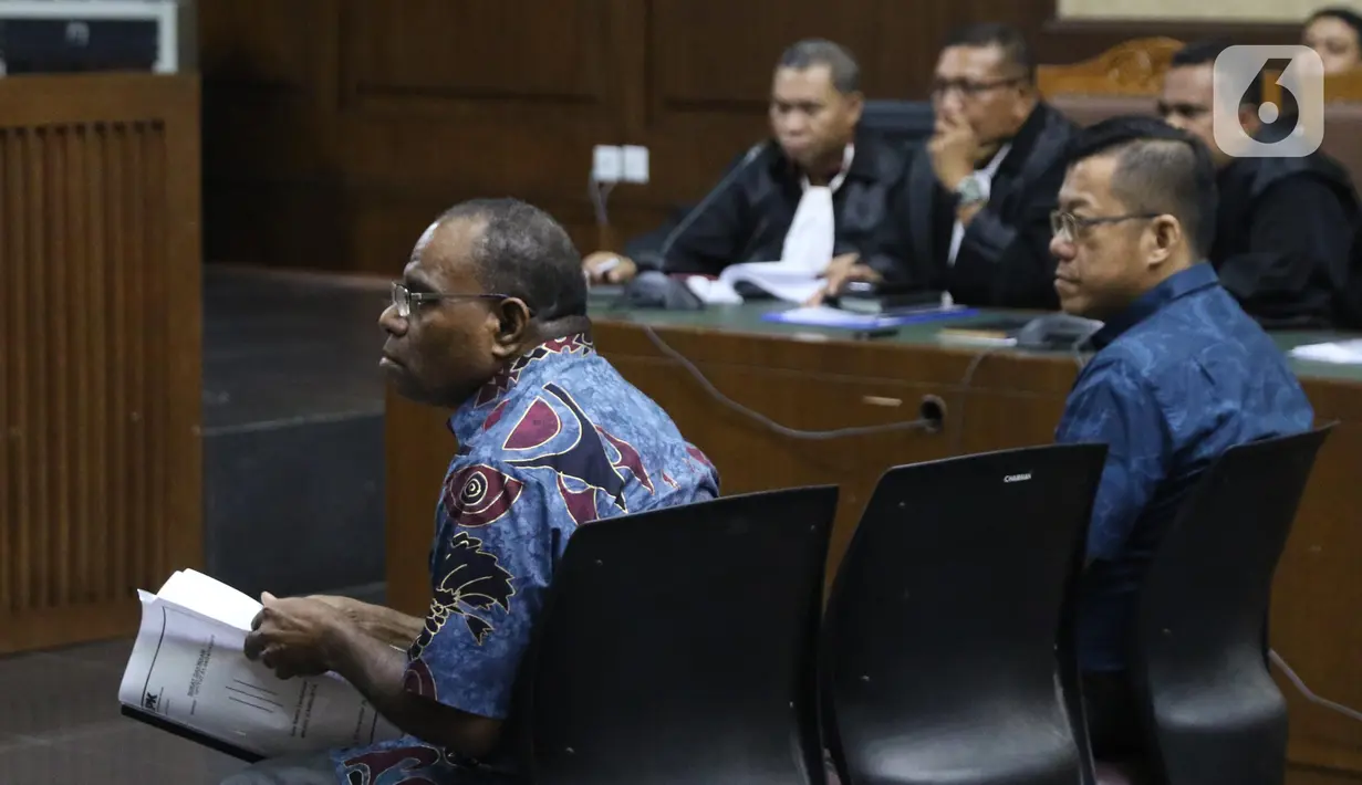 Mantan Kadis PU Papua, Mikael Kambuaya (kiri) dan Komisaris PT Manbers Jaya Mandiri, David Manibui saat sidang dakwaan di Pengadilan Tipikor Jakarta, Rabu (20/11/2019). Keduanya didakwa dalam kasus dugaan suap pekerjaan peningkatan jalan Kemiri-Depapre TA 2015. (Liputan6.com/Helmi Fithriansyah)