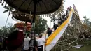 Sejumlah warga menyiapkan arak-arakan Bade atau menara bertingkat sembilan yang berisi jenazah anggota keluarga dari pahlawan nasional I Gusti Ngurah Rai dalam prosesi upacara Ngaben di Desa Carangsari, Badung, Bali, Senin (29/4/2019). (SONNY TUMBELAKA/AFP)