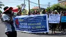 Ikatan Mahasiswa Pelajar dan Masyarakat Papua (IMMAPA) membawa spanduk saat berunjuk rasa di Lapangan Niti Mandala, Denpasar, Bali, Kamis (22/8/2019). Protes atas insiden yang terjadi di Asrama Papua di Surabaya ini diikuti oleh puluhan peserta. (SONNY TUMBELAKA/AFP)