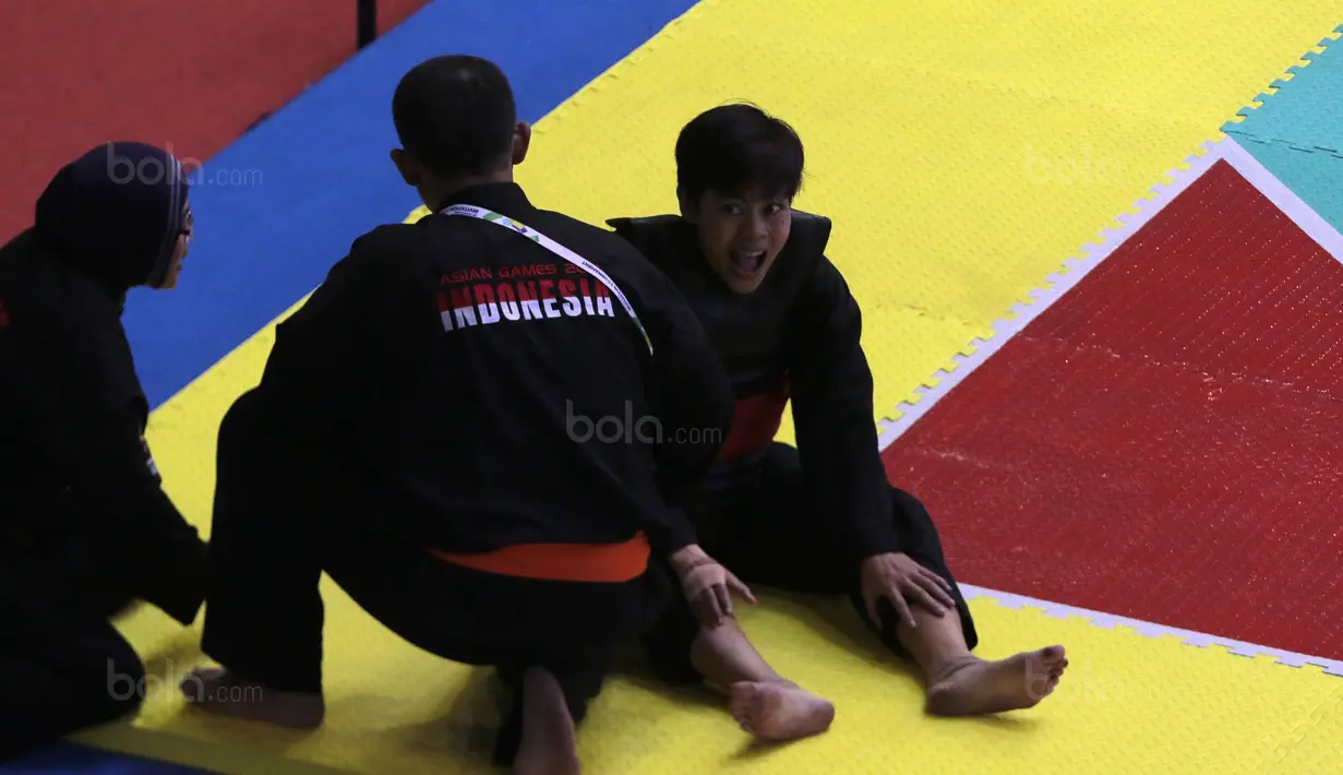 Ekspresi Octaviani Nirmalasari (kanan) mendengar arahan pelatih saat melawan pesilat Laos, Olahthai Sounthavong pada semifinal Test Event Pencak Silat 2018 di Padepokan Silat TMII, Jakarta, (12/2/2018). Oktaviani menang 5-0. (Bola.com/Nick Hanoatubun)