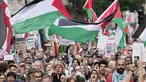 Para pendukung pro-Palestina memegang plakat dan mengibarkan bendera di Downing Street di pusat kota London, Inggris pada 19 Juli 2025. (CARLOS JASSO/AFP)