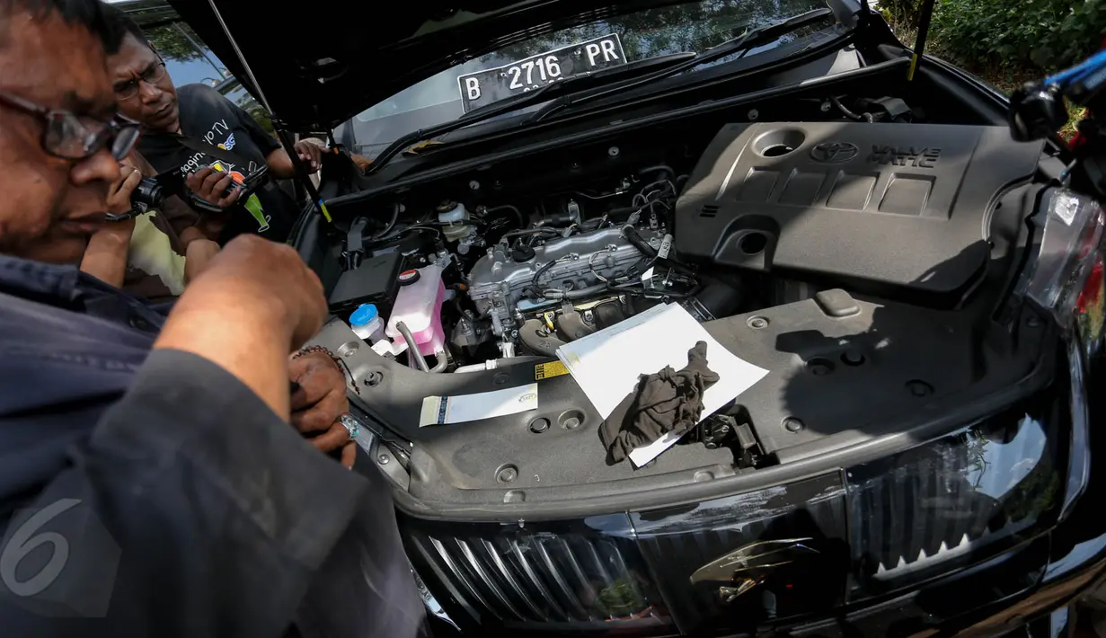Petugas melihat bagian mesin dari mobil mewah bodong yang berhasil diamankan petugas Satlantas Jakarta Utara dalam operasi yang digelar mulai 27 Mei hingga 11 Juni 2015, Jakarta, Kamis (28/5/2015). (Liputan6.com/Faizal Fanani)