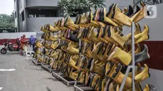 Tim Sterilisasi menjemur sepatu yang digunakan tenaga kesehatan di Rumah Sakit Darurat (RSD) Wisma Atlet Kemayoran, Jakarta. Dalam sehari Tim Sterilisasi mampu mencuci hingga 300 pasang sepatu yang telah digunakan tenaga kesehatan yang bertugas menangani pasien Covid-19. (merdeka.com/Iqbal Nugroho)