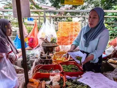Seorang pedagang menyiapkan pesanan pelanggan di sebuah kios di pasar tradisional di Jakarta pada Rabu 3 Juni 2026. (BAY ISMOYO/AFP)
