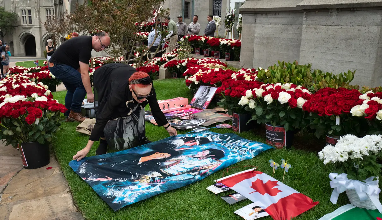 Penggemar membentangkan spanduk di luar tempat peristirahatan terakhir Michael Jackson di mausoleum Holly di Terrace Forest Lawn Cemetery, California, Selasa (25/6/2019). Tepat pada hari ini sepuluh tahun yang lalu berita kematian King of Pop Michael Jackson mengguncang dunia. (AP/Richard Vogel)
