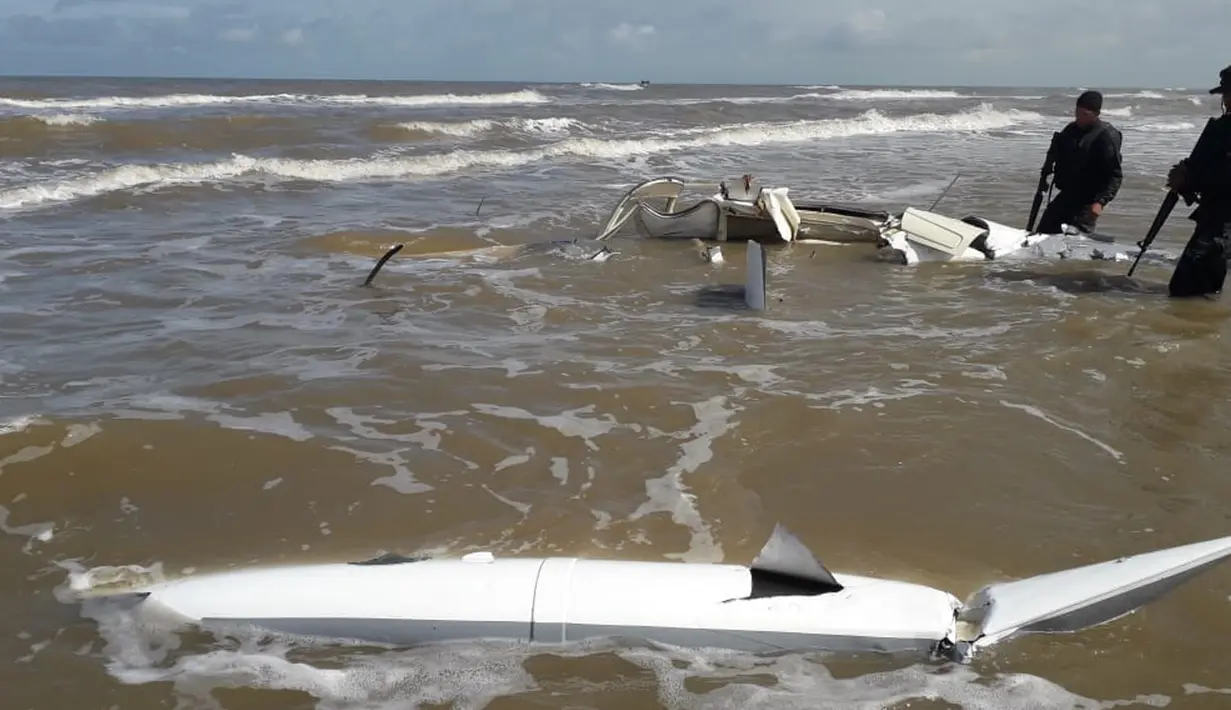 Dua tentara mengecek pesawat kecil Cessna yang jatuh di wilayah Honduras Honduras La Mosquitia di laut Karibia (18/12). Pesawat itu diduga mengangkut kokain ke departemen Gracias a Dios. (Photo by HO/Honduran Armed Forces/AFP)
