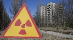 Plang nuklir terlihat di depan gedung kosong yang tidak di tinggali di kota Pripyat yang ditinggalkan penduduknya, dekat pembangkit tenaga nuklir, Ukraina, 28 Maret 2016. (REUTERS/Gleb Garanich)