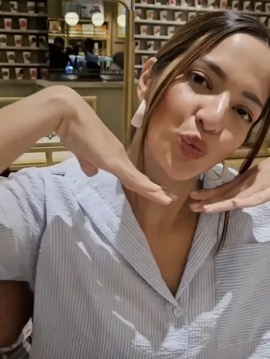 Nia Ramadhani mengenakan kemeja biru bergaris, anting-anting putih melengkapi penampilannya. [@mrsayudewi]