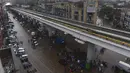 Sejumlah warga beraktivitas di bawah jembatan komuter line yang banjir setelah hujan lebat di Lahore (16/7/2019). Di Kashmir yang dikelola Pakistan, para pejabat pemerintah mengatakan sedikitnya 23 orang tewas setelah hujan lebat memicu banjir bandang. (AFP Photo/Arif Ali)