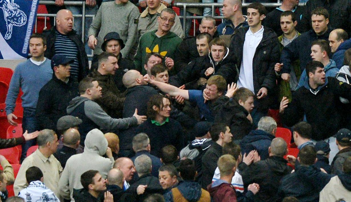Fans Millwall terlibat bentrok saat melawan klub kesayangannya melawan Wigan Athletic pada laga FA Cup di Stadion Wembley (13/4/2013). Sejak berdiri pada 1885 hingga sekarang, Millwall adalah satu di antara klub yang paling dibenci di Inggris. Penyebabnya, suporter sering berulah, di dalam maupun di luar lapangan. (AFP/Paul Ellis)