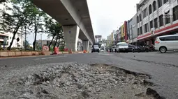 Jalanan rusak di kawasan Kelapa Gading, Jakarta, Rabu (5/9). Kondisi jalan bertambah parah sejak adanya pembangunan proyek LRT yang dapat menyebabkan kecelakaan serta mengancam keselamatan pengendara. (Merdeka.com/Iqbal S. Nugroho)