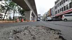 Jalanan rusak di kawasan Kelapa Gading, Jakarta, Rabu (5/9). Kondisi jalan bertambah parah sejak adanya pembangunan proyek LRT yang dapat menyebabkan kecelakaan serta mengancam keselamatan pengendara. (Merdeka.com/Iqbal S. Nugroho)