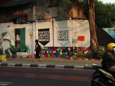 Lukisan mural dari tangan PPSU yang memanfaatkan tanaman merambat hijau menghiasi bangunan tua di kawasan Jalan Malaka, Jakarta, Selasa (29/8/2023). (Liputan6.com/Johan Tallo)