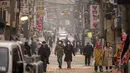 Warga mengenakan masker berjalan di jalanan selama kondisi cuaca yang tercemar di Seoul (10/12/2019). Kementerian Lingkungan Hidup Korsel menegakkan serangkaian tindakan darurat untuk mengurangi polusi debu halus, termasuk melarang kendaraan tertentu dari jalan pusat kota. (AFP Photo/Ed Jones)