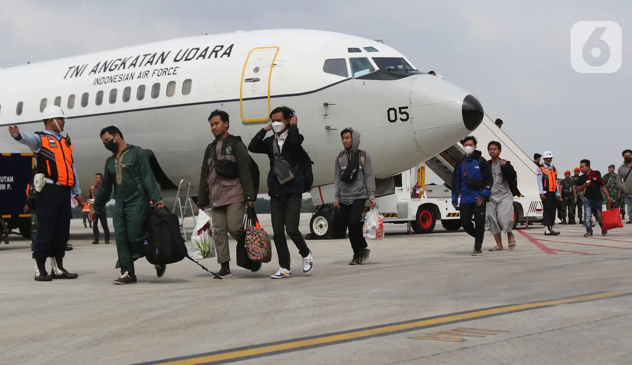 Tiga Warga Negara Indonesia (WNI) yang dipulangkan dari Sudan berjalan setibanya di Pangkalan Udara Halim Perdanakusuma, Jakarta, Senin (1/5/2023). Sebanyak 75 WNI tiba di tanah air dari Sudan dengan menggunakan pesawat TNI AU. (Liputan6.com/Helmi Fithriansyah)