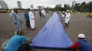 Warga mempersiapkan kelengkapan aksi damai 2 Desember di Monas, Jakarta, Kamis (1/12). Jelang aksi damai, sejumlah persiapan mulai dilakukan, seperti panggung, baris untuk Salat Jumat, hingga pengamanan dari kepolisian. (Liputan6.com/Immanuel Antonius)