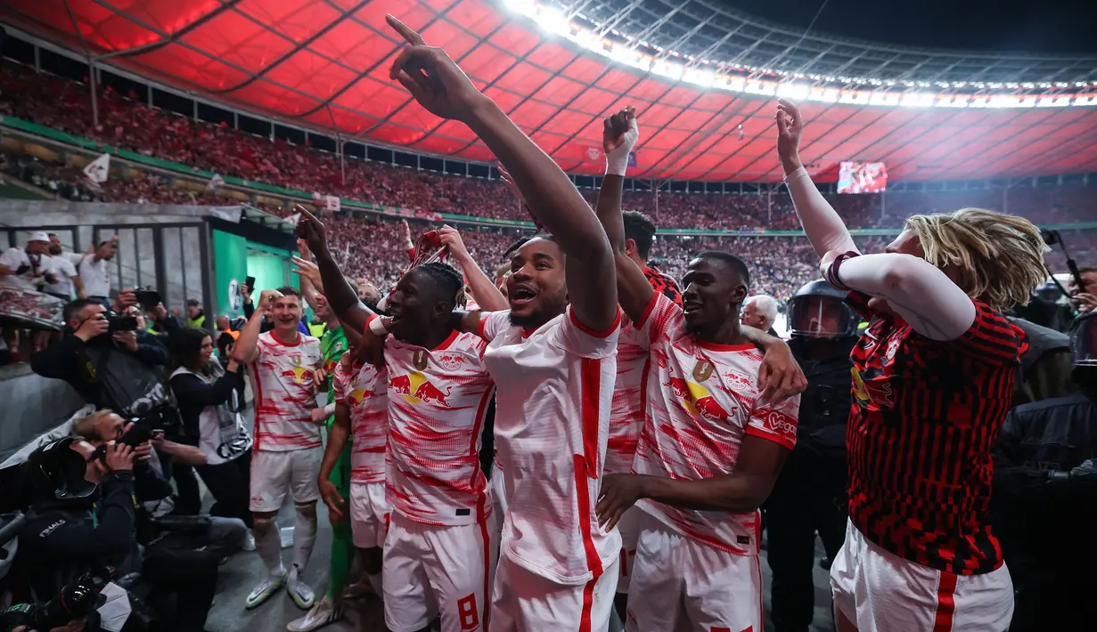 Pemain Leipzig, Christoper Nkunku (tengah) merayakan kemenangan bersama rekan setimnya usai mengalahkan SC Freiburg pada partai final DFB Pokal atau Piala Liga Jerman yang berlangsung di Stadion Olimpiade di Berlin, Jerman, Sabtu, 21 Mei 2022 waktu setempat. Die Bullen berhasil menang lewat babak adu penalti dengan skor 4-2 usai laga berjalan imbang 1-1. (AFP/Ronny Hartmann)