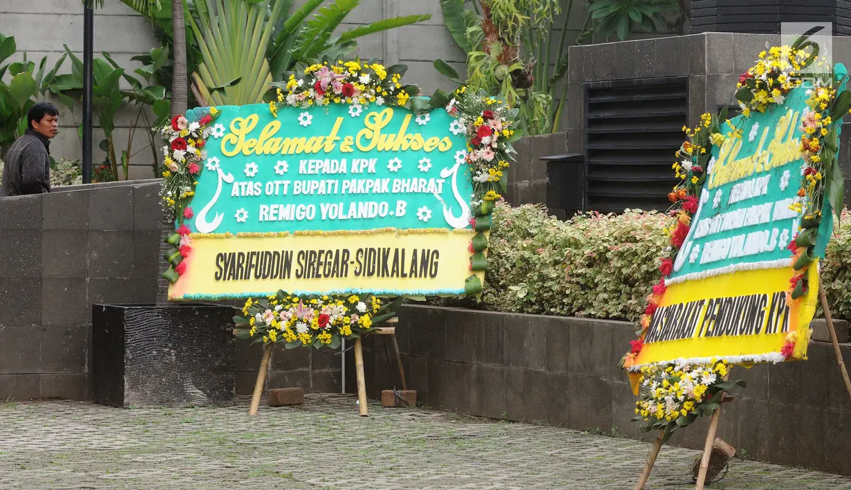 Dua karangan bunga menghiasi depan gedung KPK di Jakarta, Jumat (23/11). Karangan bunga tersebut sebagai ungkapan terima kasih atas operasi tangkap tangan (OTT) KPK terhadap Bupati Pakpak Bharat, Remigo Yolanda Berutu. (Merdeka.com/Dwi Narwoko)