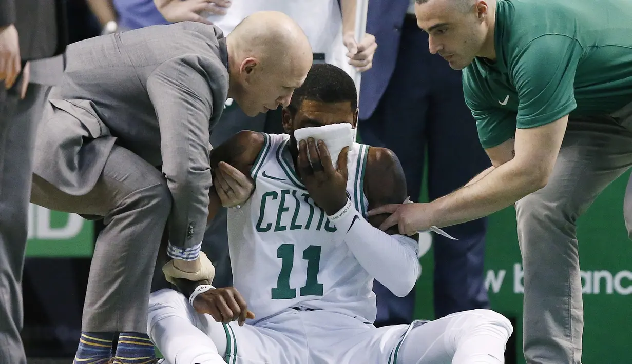 Tim medis mengobati pemain Boston Celtics, Kyrie Irving (11) saat melawan Hornets pada laga NBA basketball game di TD Garden, Boston, (10/11/2017) waktu setempat. Boston Celtics menang 90-87. (AP/Michael Dwyer)