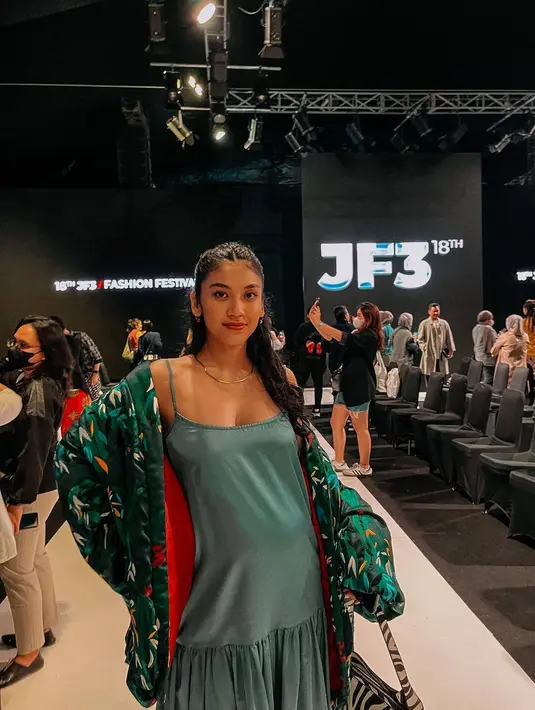 Mengenakan terusan berwarna hijau dipadu outer warna senada, Canti Tachril hadir di JF3. Ia berpose di atas catwalk. (Foto: Instagram/@cantitachril)