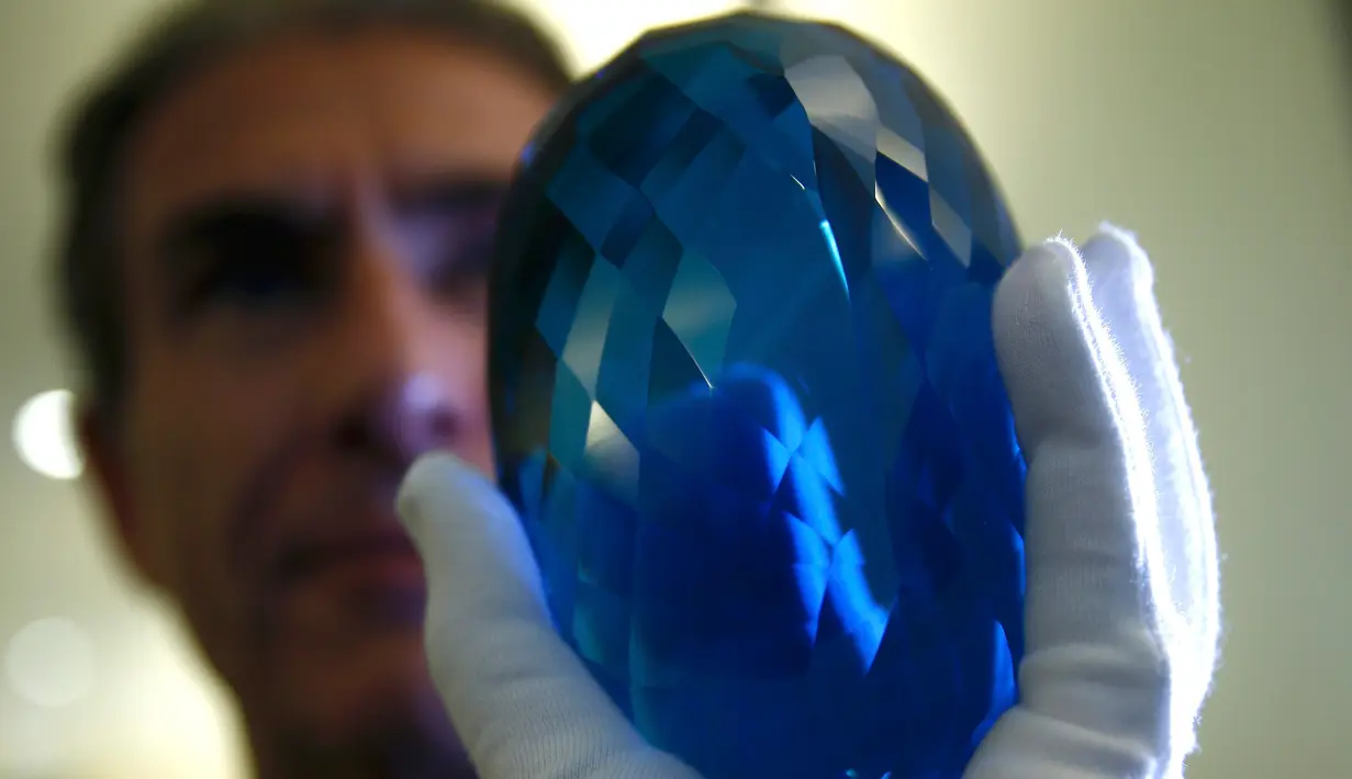 Pengusaha Inggris dan filantropis Maurice Ostro memperlihatkan batu topaz miliknya, Inggris, Selasa (27/9). Batu topaz terbesar di dunia ini memiliki berat 2 kg. (REUTERS / Peter Nicholls)